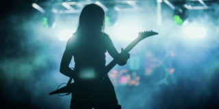 Foto de un hombre tocando guitarra eléctrica en tarima de Rock al Parque.