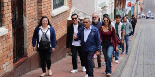 Foto de un guía de turismo, recorriendo las calles del centro de Bogotá con un grupo de turistas.