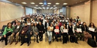 Personas mostrando el diploma de graduados en Bogotá.