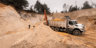 Camión de carga y retroexcavadora junto a montículos de arena en una zona de extracción intervenida durante operativo contra la minería ilegal en Chocontá.