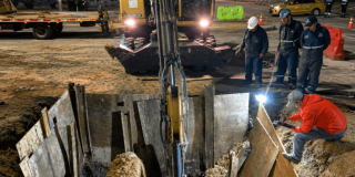 Foto que muestra un hueco en el piso y personas trabajando 