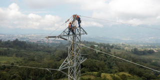 Foto de operarios de Enel realizando mantenimiento a las torres de energía.