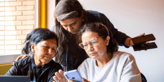 Tres mujeres viendo un celular durante un encuentro en Bogotá.