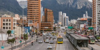 Foto de una vía de Bogotá donde se ven buses de TransMilenio y carros
