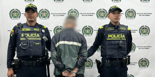 Hombre capturado en medio de dos policías.