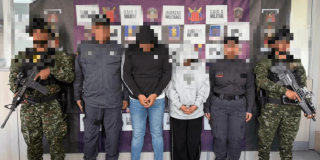 Dos personas capturadas, en medio de dos militares y dos agentes del CTI de la Fiscalía.
