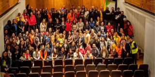 participantes de los Comités de Ayuda Mutua reunidos en un auditorio, posando para una fotografía grupal en las escaleras y pasillos laterales.