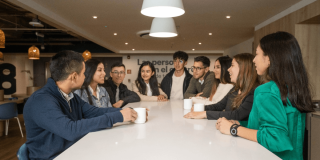Foto que muestra un grupo de personas sentadas hablando