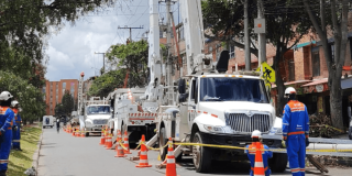 Foto de un camión y trabajadores de Enel en labores de mantenimiento.