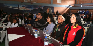 Foto de grupo de docentes como jurados de un evento escolar en el aula múltiple de un colegio.