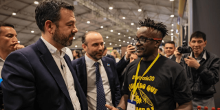 Alcaldes de Bogotá y Cali Personas conversan con un participante del Festival Petronio Álvarez un estand durante un evento en Corferias por la Feria del Hogar 2026.