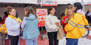 Foto de un grupo de ciudadanos recibiendo asesoría de funcionarios de la Secretaría Distrital de Integración Social en un evento público en una plazoleta de Bogotá.