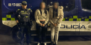 Foto que muestra una policía y dos mujeres capturadas 
