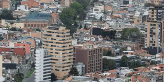 Vista panorámica de un sector urbano de Bogotá con edificaciones residenciales y comerciales de diferentes alturas. En primer plano se observan varios edificios de apartamentos y oficinas.