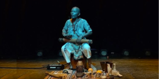 Imagen del artista afroperuano sentado tocando un timbal.