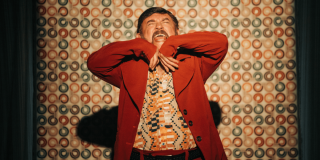 Imagen de un hombre vestido de color café gritando.