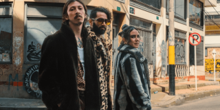 Imagen de 2 hombres y una mujer con abrigos con fondo de calle con graffitis