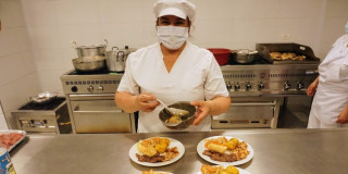 Una señora preparando alimentos en un comedor comunitario
