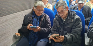 Dos adultos mayores revisando el celular 