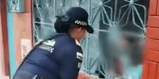 Mujer policía verificando la situación en la que se encontraban estos dos niños.
