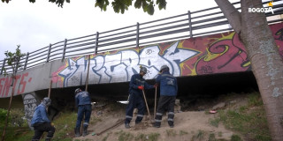 Personal del IDU cerrando un hueco debajo de un puente peatonal 