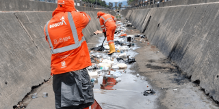 Foto que muestra personas limpiando un canal de agua 