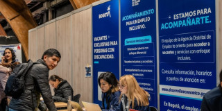 Participante en la Megaferia de Empleo junto a funcionarias de la Alcaldía de Bogotá