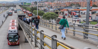 Foto de una calle de la ciudad de Bogotá donde se ven personas y buses