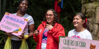 Funcionaria de la Secretaría de Inclusión Social junto a dos participantes de la jornada