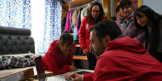 Foto del alcalde Carlos Fernando Galán junto a la familia de María del Carmen Zabala durante la entrega de computadores del programa 'Conexión Social'.