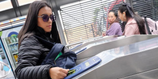 Foto de una mujer accediendo a una estación de TransMilenio en Bogotá.