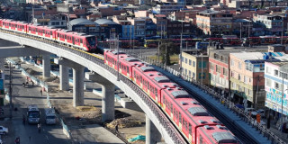 Foto de dos trenes de la Línea 1 del Metro de Bogotá, circulando sobre el viaducto.
