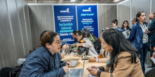 Ciudadana en una feria de empleo en Bogotá junto a una funcionaria de la Secretaría Distrital del Desarrollo Económico