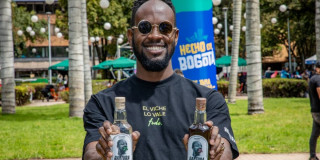 Comerciante enseñando dos botellas de viche.