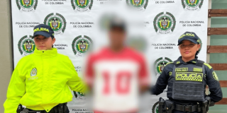 Foto de un hombre capturado en medio de dos policías.