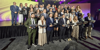 Foto que muestra personas sonriendo con un trofeo en las manos
