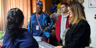 Foto de funcionarios del Distrito entregando ayudas 