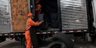 Trabajadores subiendo llantas en un camión 