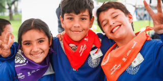 Foto una niña y dos niños sonriendo.