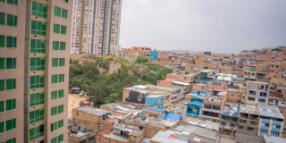 Vista panorámica de un barrio de Bogotá con viviendas de ladrillo, edificios residenciales y zonas verdes.