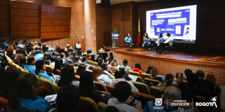 Foto que muestra personas sentadas en un auditorio 