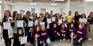Foto que muestra mujeres sonriendo con diplomas en las manos 