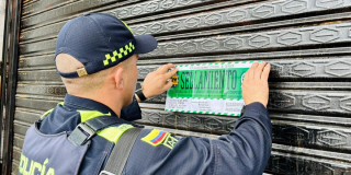 Foto de un policía sellando un establecimiento 