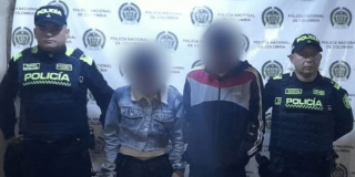 Foto de dos capturados esposados, en medio de dos policías.