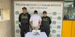 Foto de hombre capturado en medio de dos policías.