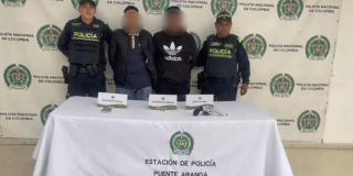 Foto de dos capturados en medio de dos Policías.