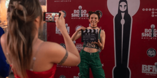 Imagen de una mujer fondo de Bogoshorts con una claqueta y otra grabándola con un celular