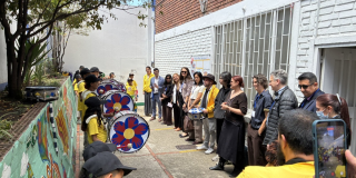 Grupo de personas de una entidad de vocación social dan la bienvenida a invitados especiales con una muestra cultural usando instrumentos musicales. 