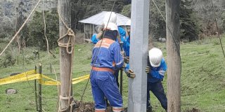 Trabajadores de Enel Colombia cambiando un poste de energía.