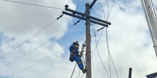 Trabajador de Enel subido en un poste de luz durante labores de mantenimiento.